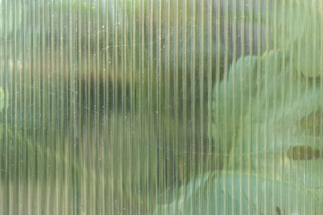 The texture of transparent polycarbonate. Transparent plastic material greenhouses. Corrugated white polycarbonate texture. Polycarbonate texture close-up.